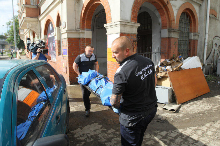 Przygnębiająca chwila - pracownicy firmy pogrzebowej wynoszą zwłoki ofiar ulewy. Gdyby nie ta tragedia, można by powiedzieć, że Gdańsk przeszedł przez atak żywiołu małym kosztem.