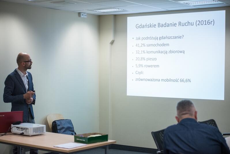 Tomasz Janiszewski z FRAG przybliża temat transportu samochodowego w Gdańsku. Przed dyskusjami przy stolikach, każdy moderator przedstawiał krótki wstęp dotycząc tematu dyskusji