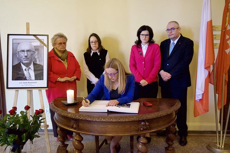 Do księgi poświęconej pamięci prof. Jacka Namieśnika wpisuje się przewodnicząca Rady Miasta Gdańska Agnieszka Owczarczak. Stoją: Teresa Wasilewska - wiceprzewodnicząca RMG, radna miasta Gdańska Kamila Błaszczyk, prezydent Gdańska Aleksandra Dulkiewicz i Piotr Kowalczuk - zca prezydenta Gdańska