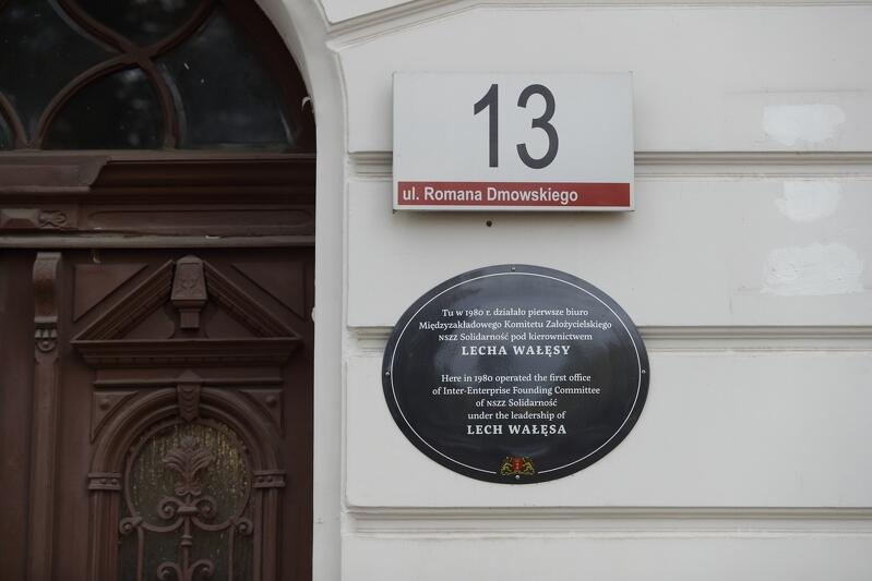 Tablica przy ulicy Dmowskiego 13 - na kamienicy, w której jesienią 1980 roku mieściło się pierwsze, tymczasowe biuro Międzyzakładowego Komitetu Założycielskiego Niezależnego Samorządnego Związku Zawodowego (jeszcze bez dodatku „Solidarność” w nazwie)