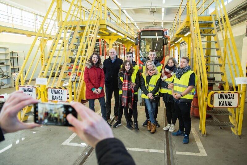 Pamiątkowe zdjęcie w hali przeglądów technicznych. Grupę oprowadzali (pierwsi od lewej): Karolina Kowalska specjalistka ds. marketingu GAiT oraz Piotr Myca kierownik zajezdni Wrzeszcz