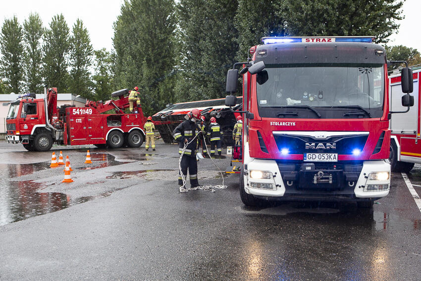 Podnoszenie autobusu, który przewrócił się na samochody