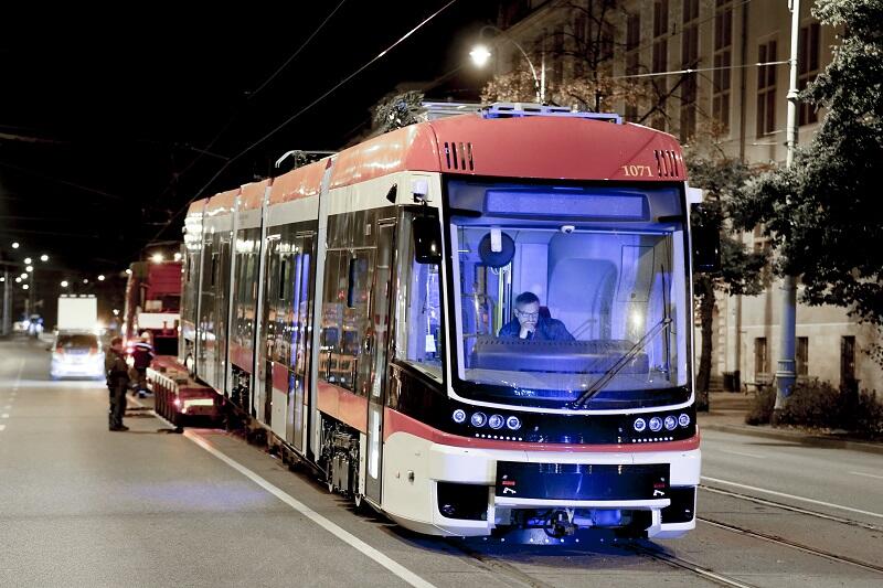 Noc, z lawety na tory zjechał nowy tramwaj, na pierwszym planie kabina motorniczego, rozświetlona jaskrawo niebieskim światłem, motorniczy siedzi w środku