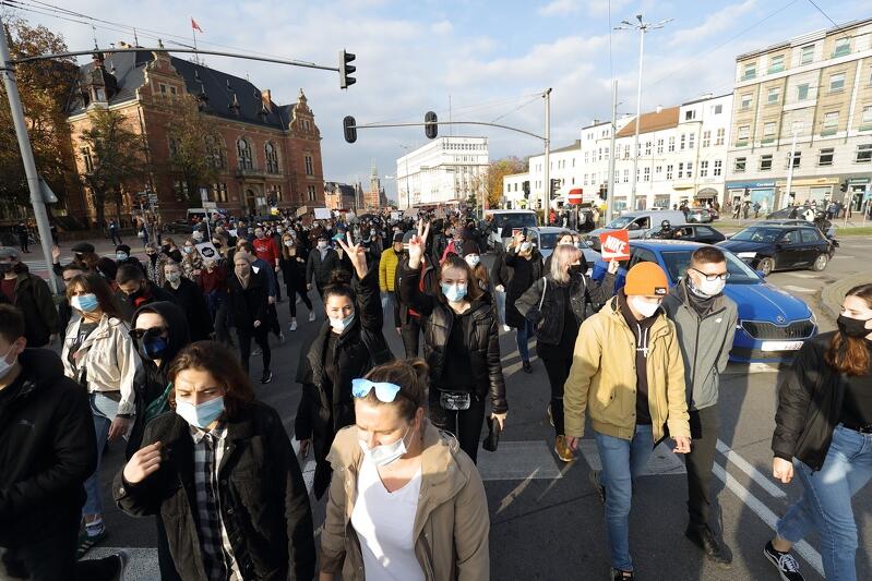 Blokada przez idących jezdnią demonstrantów ronda Hucisko, dużo osób na ulicy, w tle siedziba Rady Miasta