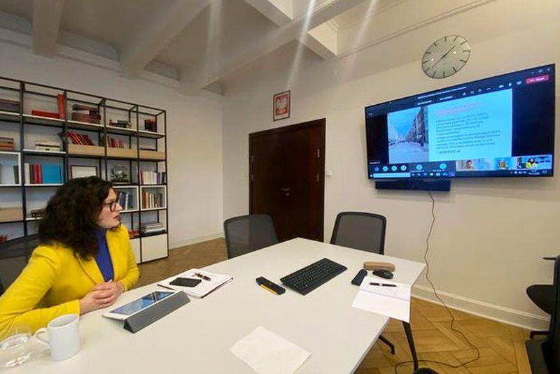 Narada internetowa, przy stole prezydent Gdańska na ścianie ekran telewizora, a w nim rozmówcy