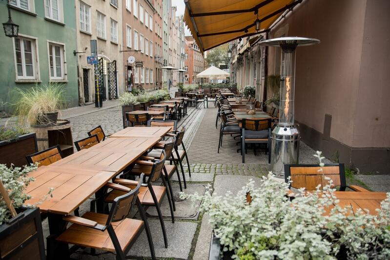 ogródek gastronomiczny w starej części Gdańska, wszystkie stoliki stoją puste