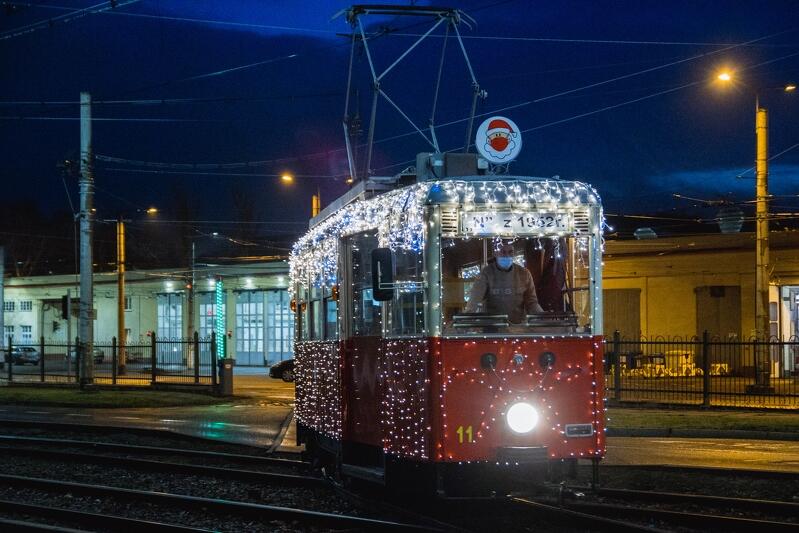 świąteczny tramwaj na torach - jest udekorowany kolorowymi lampkami