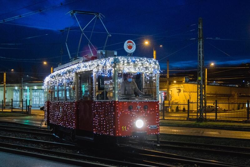 świąteczny tramwaj na torach - jest udekorowany kolorowymi lampkami