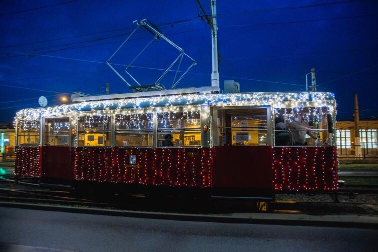 świąteczny tramwaj na torach - jest udekorowany kolorowymi lampkami