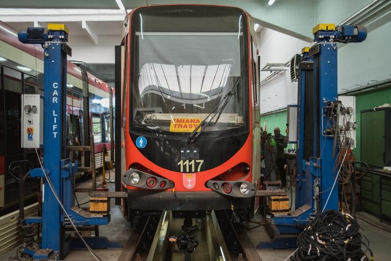 tramwaj na podnośniku, z karoserii wykręcone lampy przednie, wokół zwoje kabli