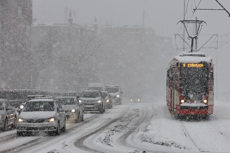 Ulica w Gdańsku, duże opady śniegu widać jadące samochody i tramwaj