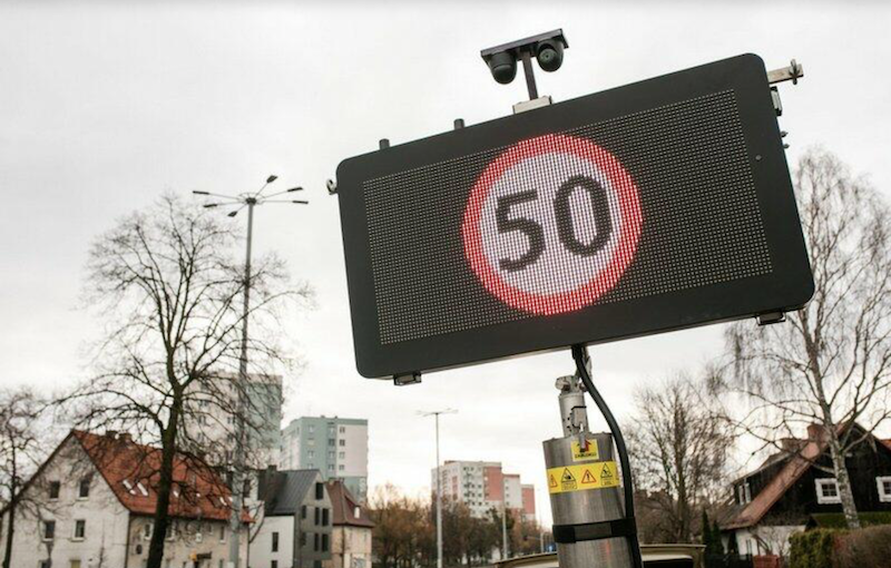 Tablica zmiennej treści przedstawiająca znak ograniczenia prędkości do 50 km/h na czarnym tle