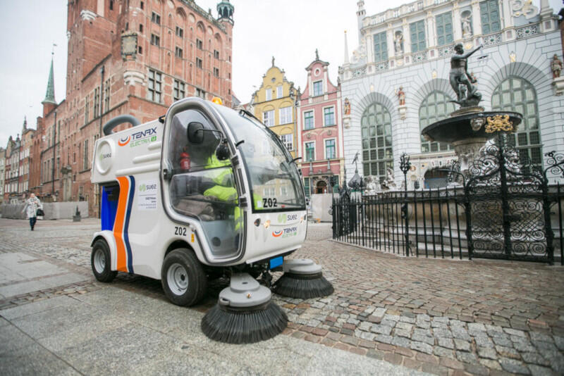 zamiatarka na długim targu, od razu po prawej stronie fontanna neptuna, w tle ratusz głównego miasta