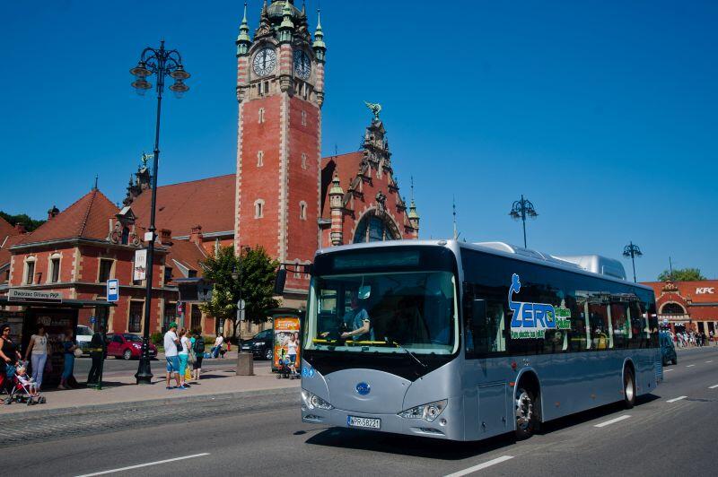 nowoczesny autobus mknie główną ulica Gdańska w tle dworzec główny PKP