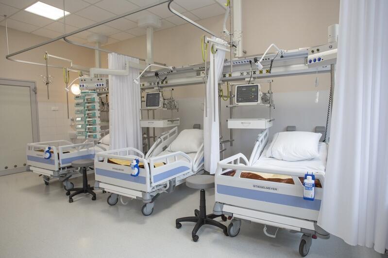 Sala szpitalna, trzy puste, nowczesne łóżka szpitalne, oddzielone zasłonami