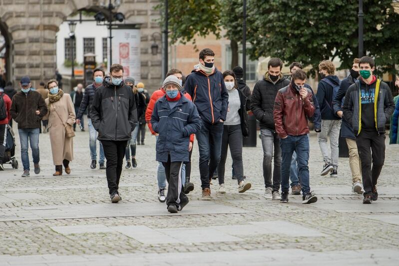 Ulica Długi Targ w Gdańsku, idzie tłum ludzi w różnym wieku, w kurtkach, z maseczkami na twarzy 