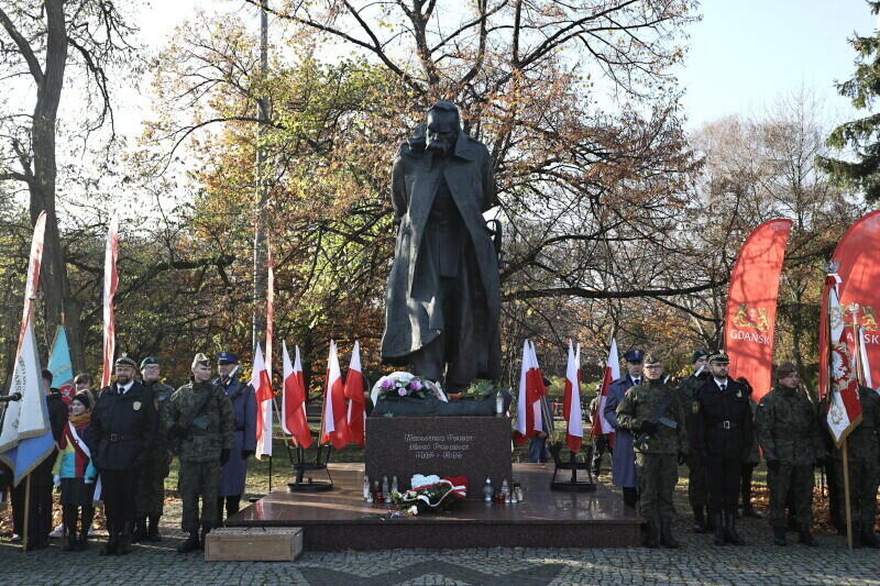 Pomnik Józefa Piłsudskiego, biało czerwone flagi, żołnierze, uczniowie 
