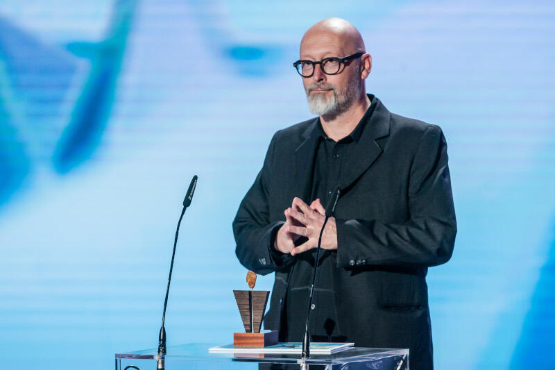 Wojciech Smarzowski to ceniony reżyser filmowy i teatralny, scenarzysta oraz operator filmowy, kawaler Orderu Odrodzenia Polski. Za „Kler” otrzymał Nagrodę Publiczności podczas Festiwalu Polskich Filmów Fabularnych w Gdyni