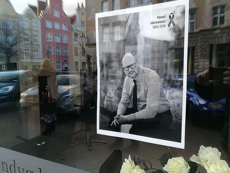 Zdjęcie zrobione w dzień po zabójstwie prezydenta Gdańska - widzimy jego fotograficzny portret z kirem, za oknem wystawowym jednego z gdańskich lokali usługowych