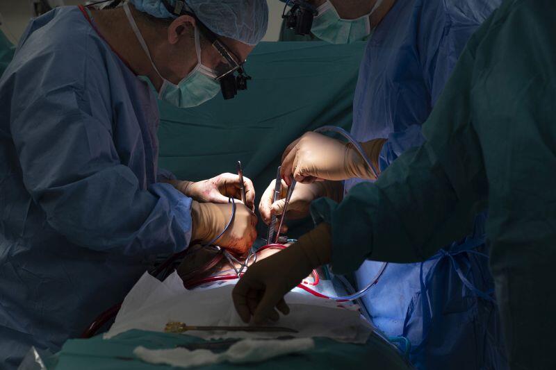 Chirurdzy pochyleni nad stołem operacyjnym