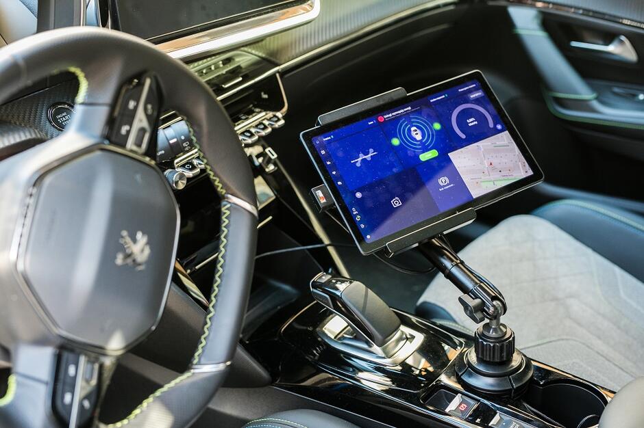 Ekran urządzenia mobilnej kontroli we wnętrzu wyposażonego weń samochodu