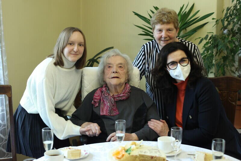 cztery kobiety reprezentujące cztery pokolenia pozują do zdjęcia, na środku seniorka, po lewej prawnuczka, z tyłu córka i pani prezydent