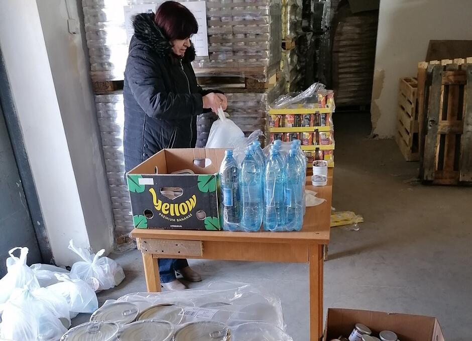 Pani Jolanta, magazynierka Banku Żywności w Trójmieście pakuje paczki z artykułami spożywczymi dla uchodźców z Ukrainy