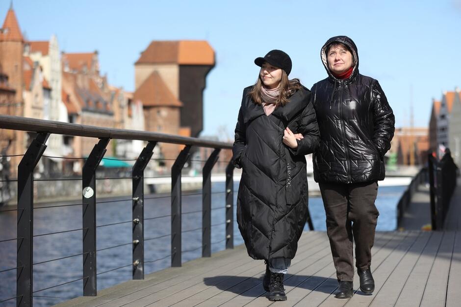 Dwie kobiet ciepło ubrane spacerują wzdłuż Motławy