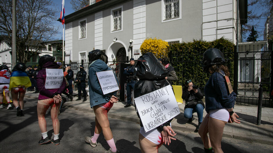 Na jednej z plansz zawieszonych na plecach protestujących napis po polsku: ROSJANIE! WASI BRACIA I SYNOWIE GWAŁCĄ NASZE UKRAIŃSKIE SIOSTRY!