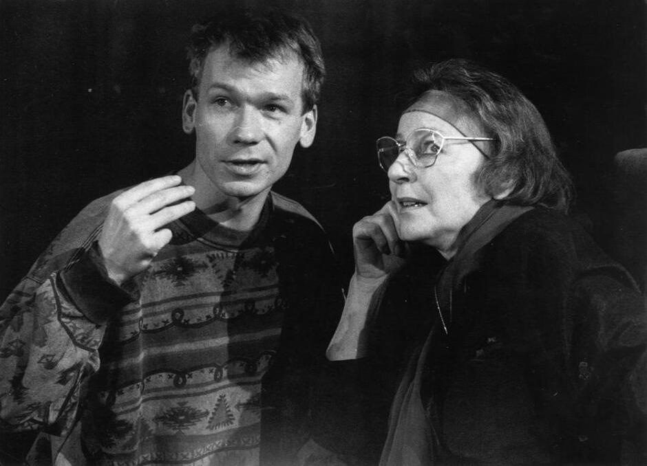 Czarno-białe zdjęcie: młodszy mężczyzna i starsza od niego kobieta w okularach