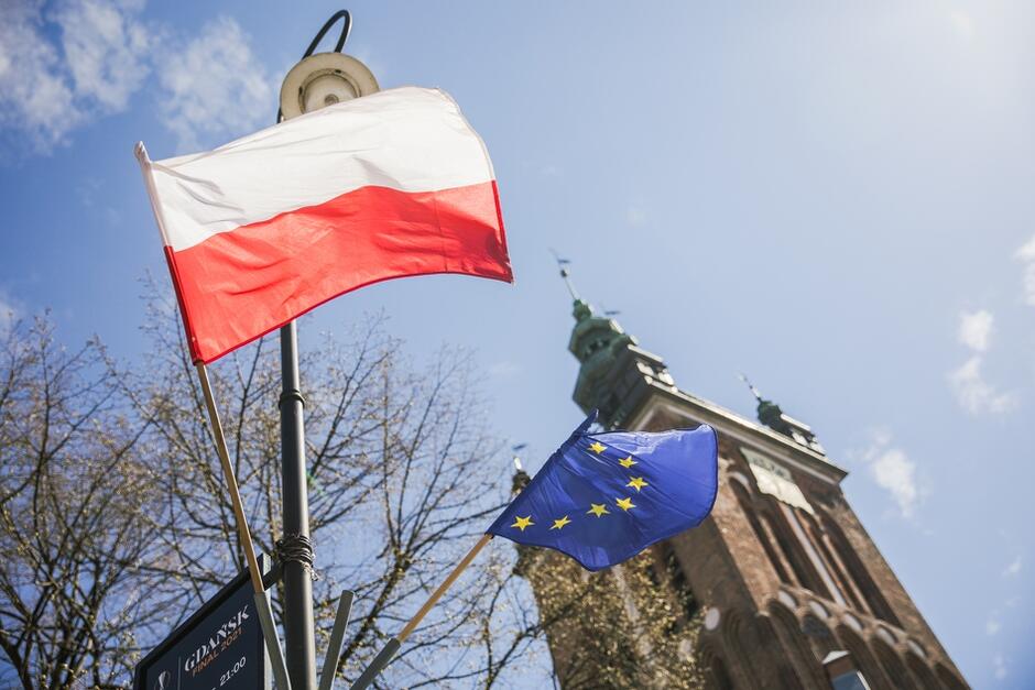 Flaga RP i flaga UE na ul. Rajskiej, pod kościołem św. Katarzyny, z wieży którego usłyszymy 9 maja koncert carillonowy na Dzień Europy
