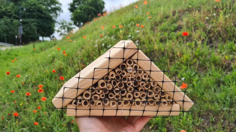 Mały drewniany domek dla owadów w kształcie trójkąta