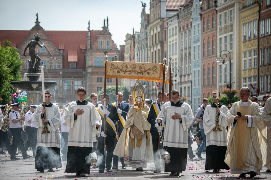 Procesja w Śródmieściu Gdańska, która wyszła z Bazyliki Mariackiej. Czoło pochodu zbliża się właśnie do Ratusza Głównego Miasta, gdzie zbudowano pierwszy z czterech ulicznych ołtarzy 