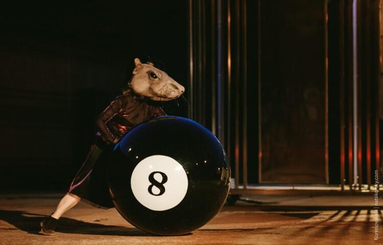 aktor w kostiumie przedstawiającym wielką mysz toczy koło z numerem 8