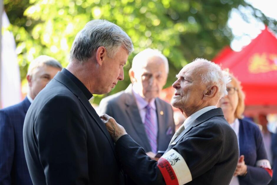 Ksiądz Ireneusz Bradtke odbiera z rąk prof. Jerzego Grzywacza Złoty Krzyż 80-lecia AK