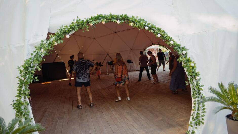 wejście na namiotu, w środku tańczą ludzie