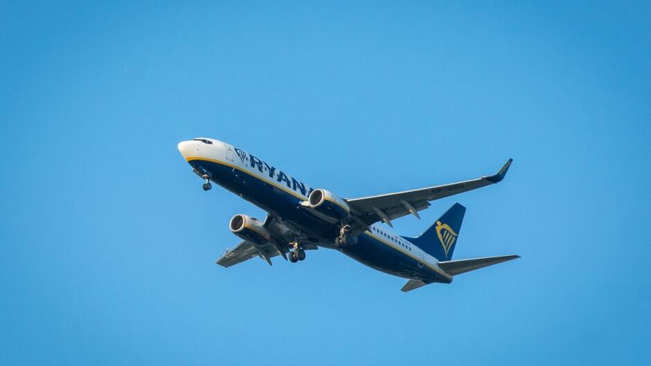 Leci samolot z napisem Ryanair, na tle niebieskiego nieba