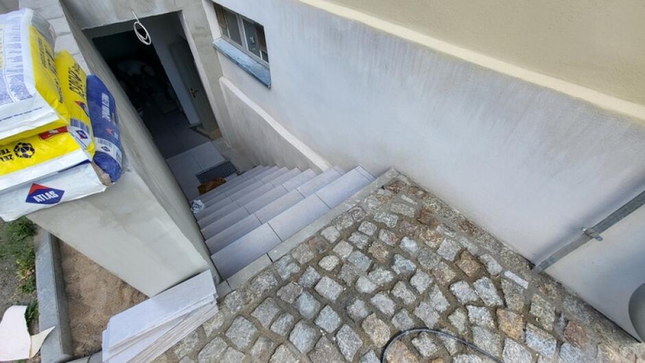 na zdjęciu schody prowadzące do pomieszczenia piwnicznego, widać otwarte drzwi do tego pomieszczenia
