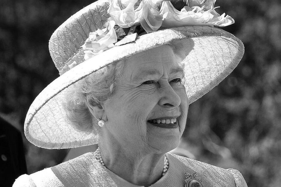Zdjęcie starszej uśmiechniętej kobiety w okazałym eleganckim kapeluszu