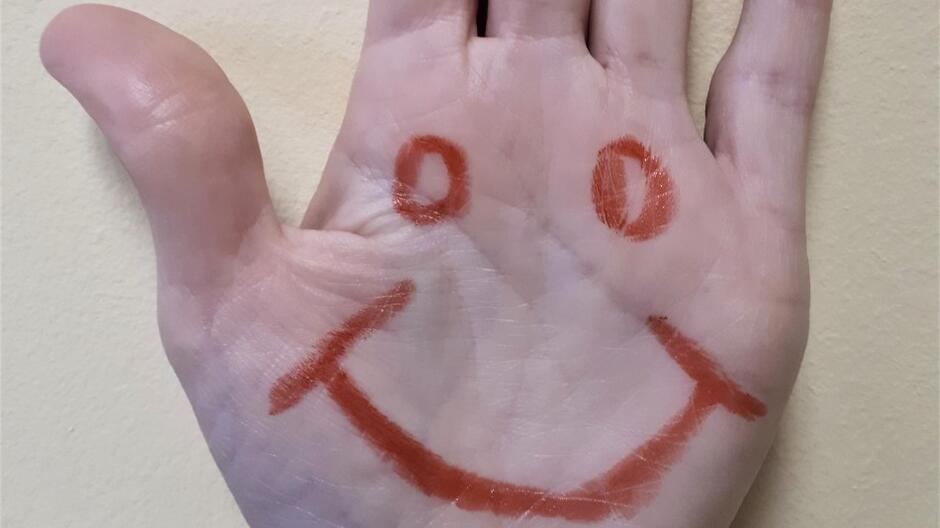Symbolem Światowego Dnia Adopcji jest uśmiechnięta buźka  na dłoni