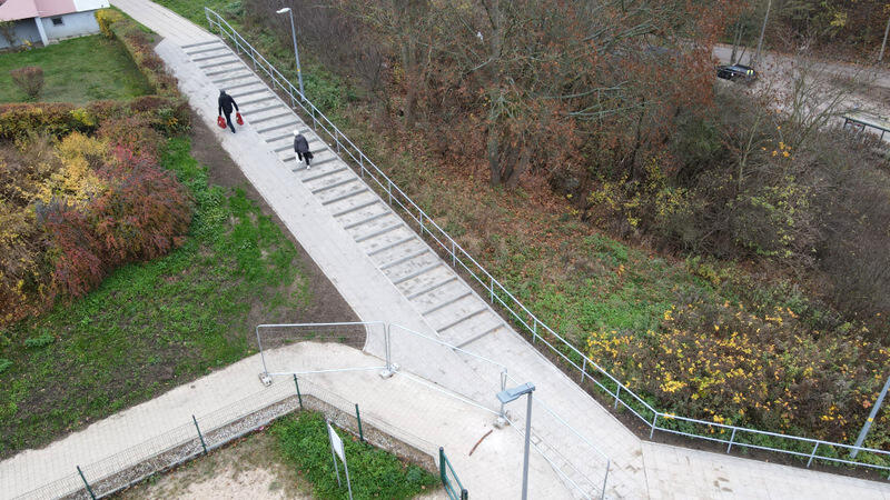 zdjęcie z drona, widać na nim nowe schody i nowy chodnik po którym idzie kilka osób