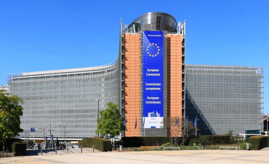 ogromny wielopiętrowy, rozłożysty gmach z wywieszonym na fasadzie logo Unii Europejskiej