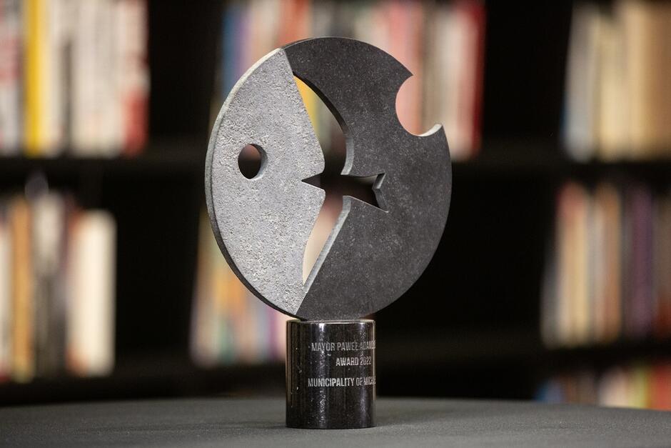 statuetka przedstawiająca płaskorzeźbę, z wykutym ptakiem, który ze strefy cienia, z mroku szybuje ku światłu