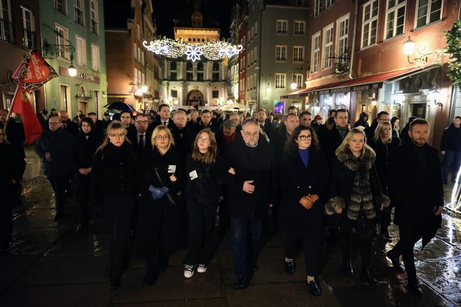 Przemarsz grupy osób ulicą Długą, uczestników obchodów 4. rocznicy śmierci Pawła Adamowicza