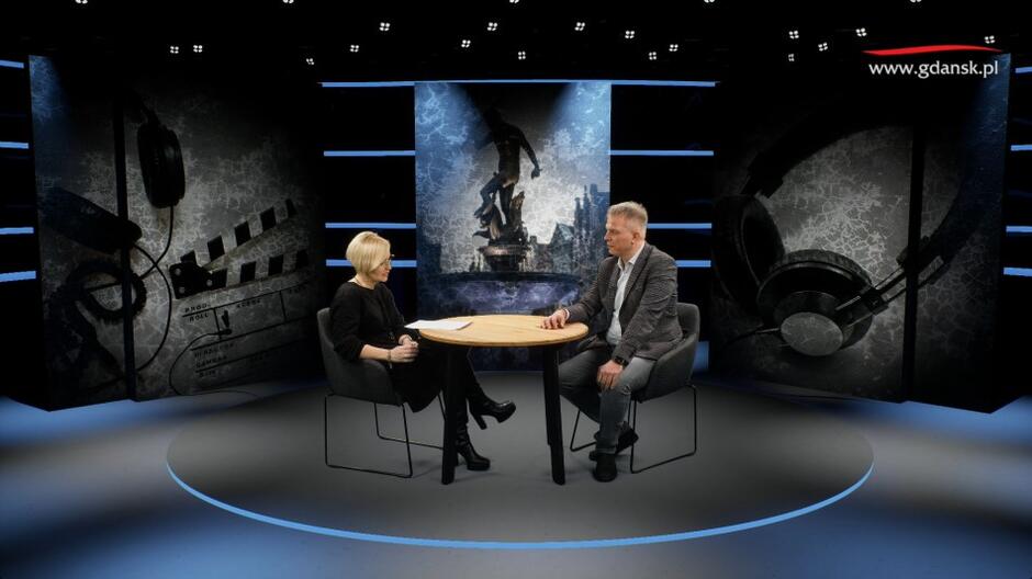 Dwie osoby - kobieta i mężczyzna - rozmawiający w studio telewizyjnym