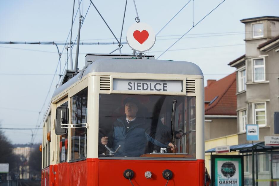 Czerwony tramwaj, na tablicy u góry napis SIEDLCE. Na dachu doczepione czerwone serce