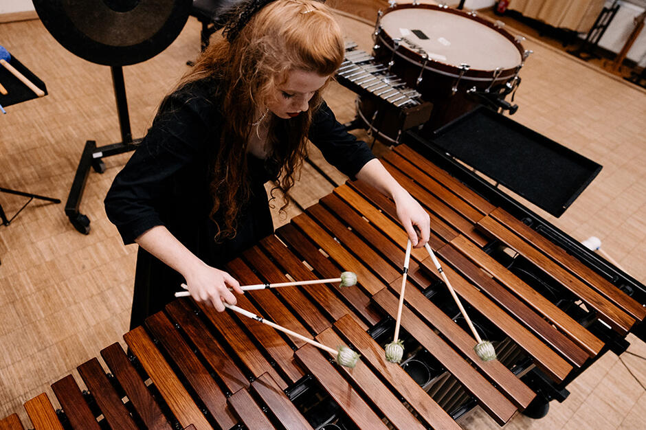 Młoda dziewczyna grająca na dużych cymbałach
