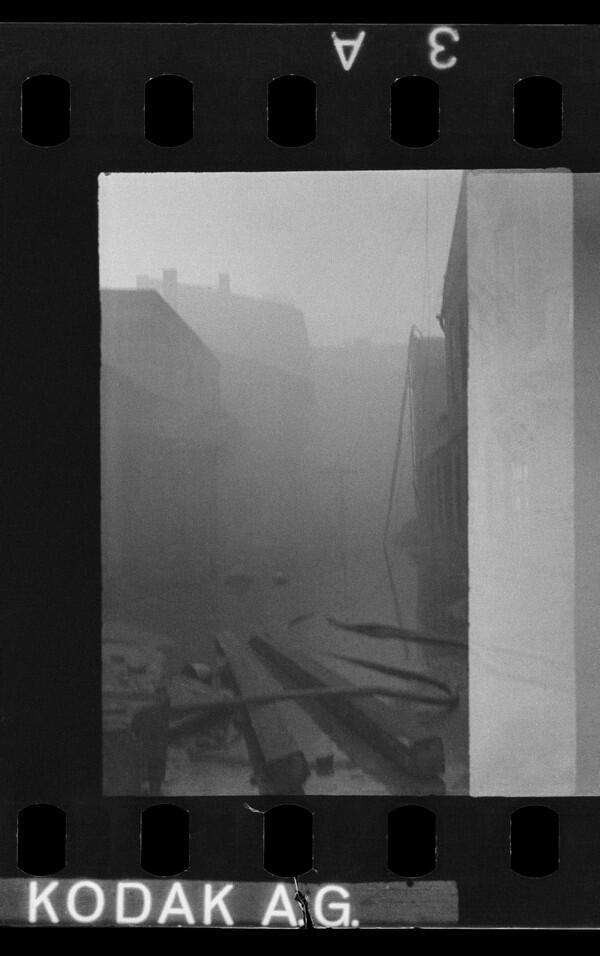 Czarno-białe zdjęcie: ulica, budynek (mało wyraźne) mgła