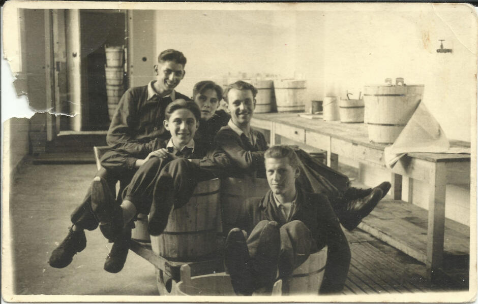 archiwalne zdjęcie, pięciu młodych mężczyzn pozuje siedząc w kadziach