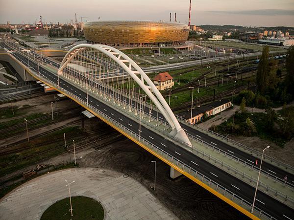 Widok z lotu ptaka na estakadę alei Macieja Płażyńskiego nad torami kolejowymi. W perspektywie widoczny stadion piłkarski w Letnicy.
